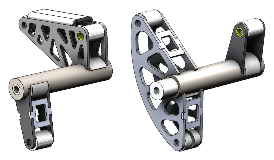 CAD renders of two rocker shaft assemblies side by side. Left: a triangular lattice-cut rocker plate on a shaft. Right: a curved lattice-cut rocker plate on a shaft that ends in a clevis.